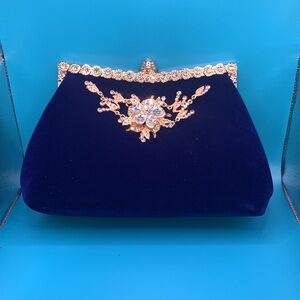 ￼
Royal blue Valore clutch with gold and embellishments